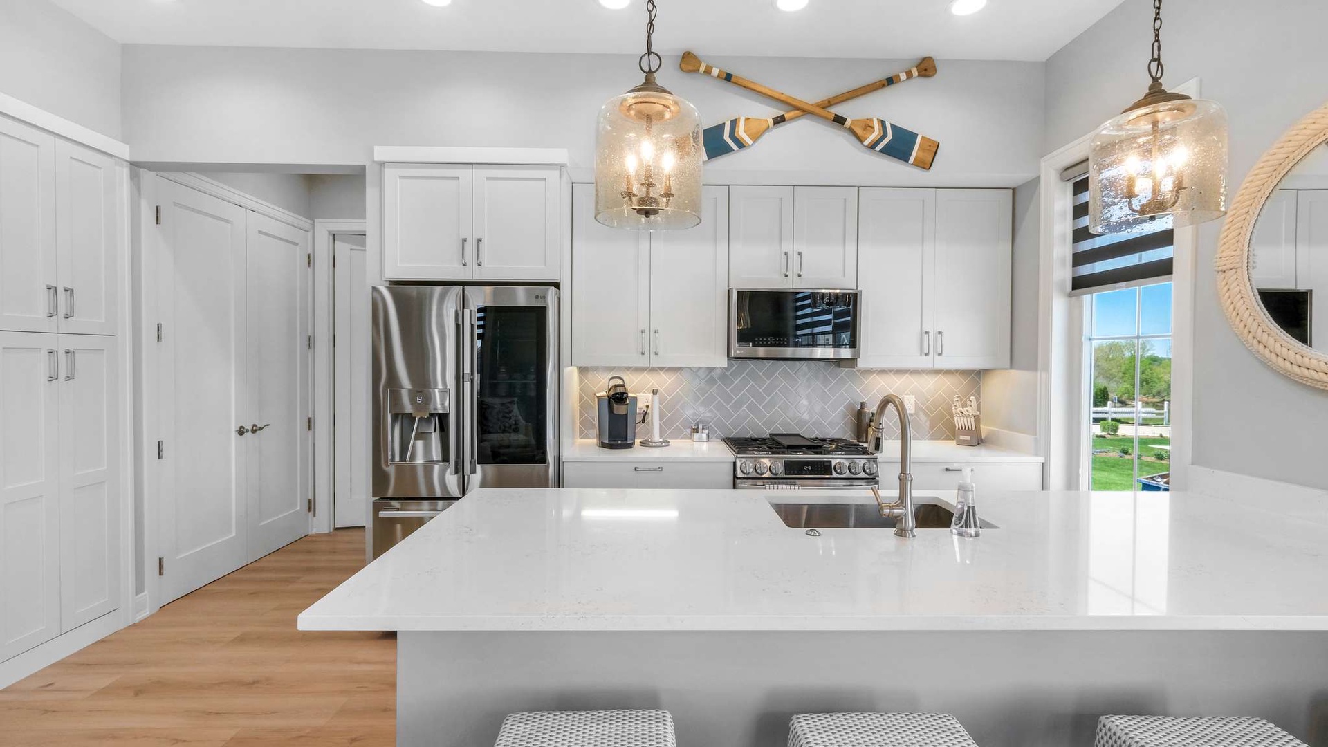 Your gourmet kitchen features gleaming white countertops, stainless steel appliances, and charming pendant lighting for memorable meal prep.