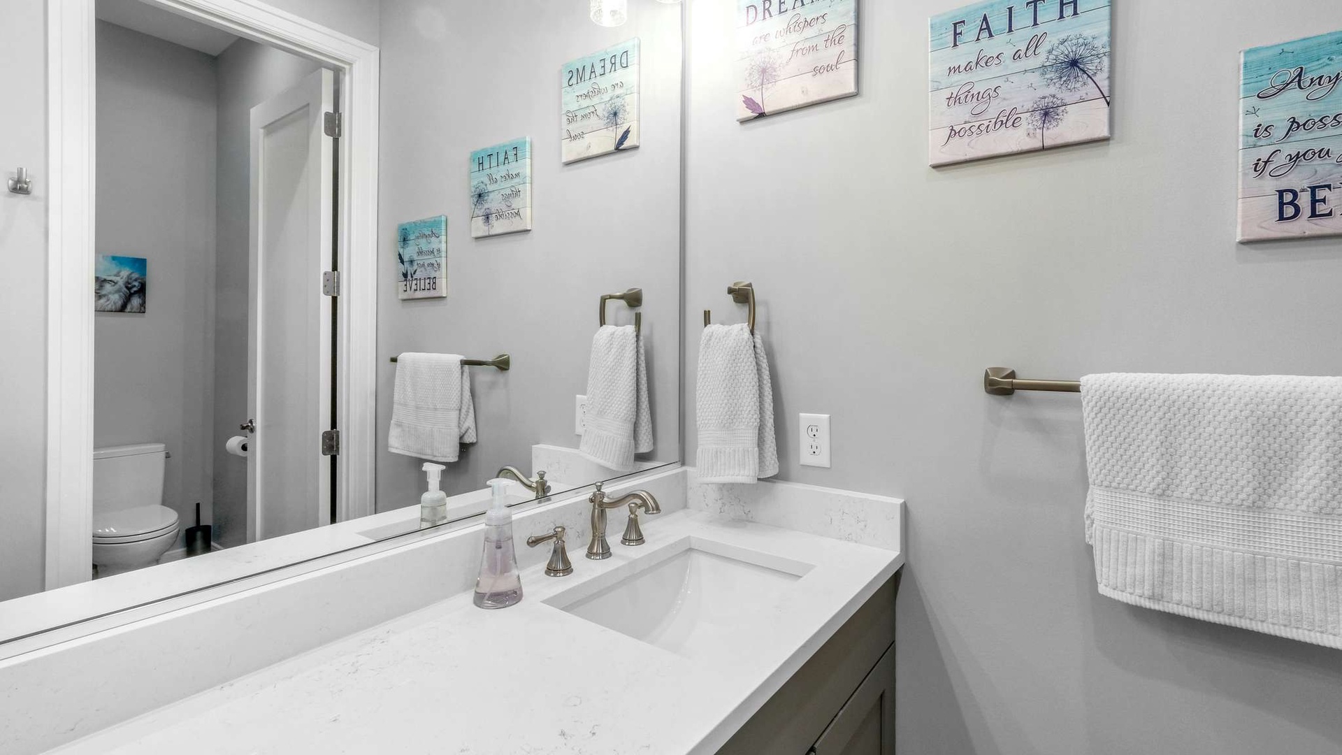 Freshen up in your pristine bathroom featuring marble countertops, inspiring coastal artwork, and plush towels that wrap you in comfort.