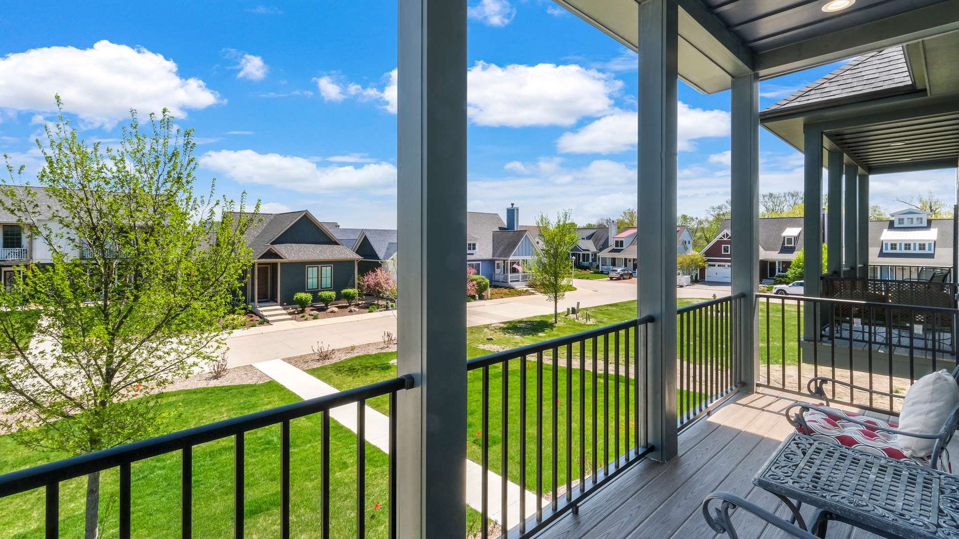 Relax on your covered balcony with comfortable seating while enjoying views of the peaceful neighborhood and green spaces below.