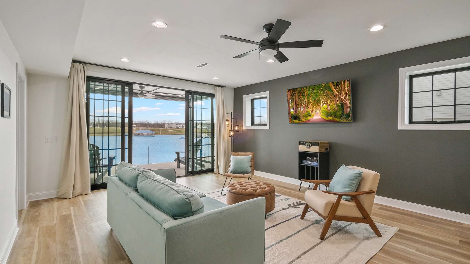 Relax in this stylish living space with stunning lake views through floor-to-ceiling windows. Your peaceful retreat awaits.