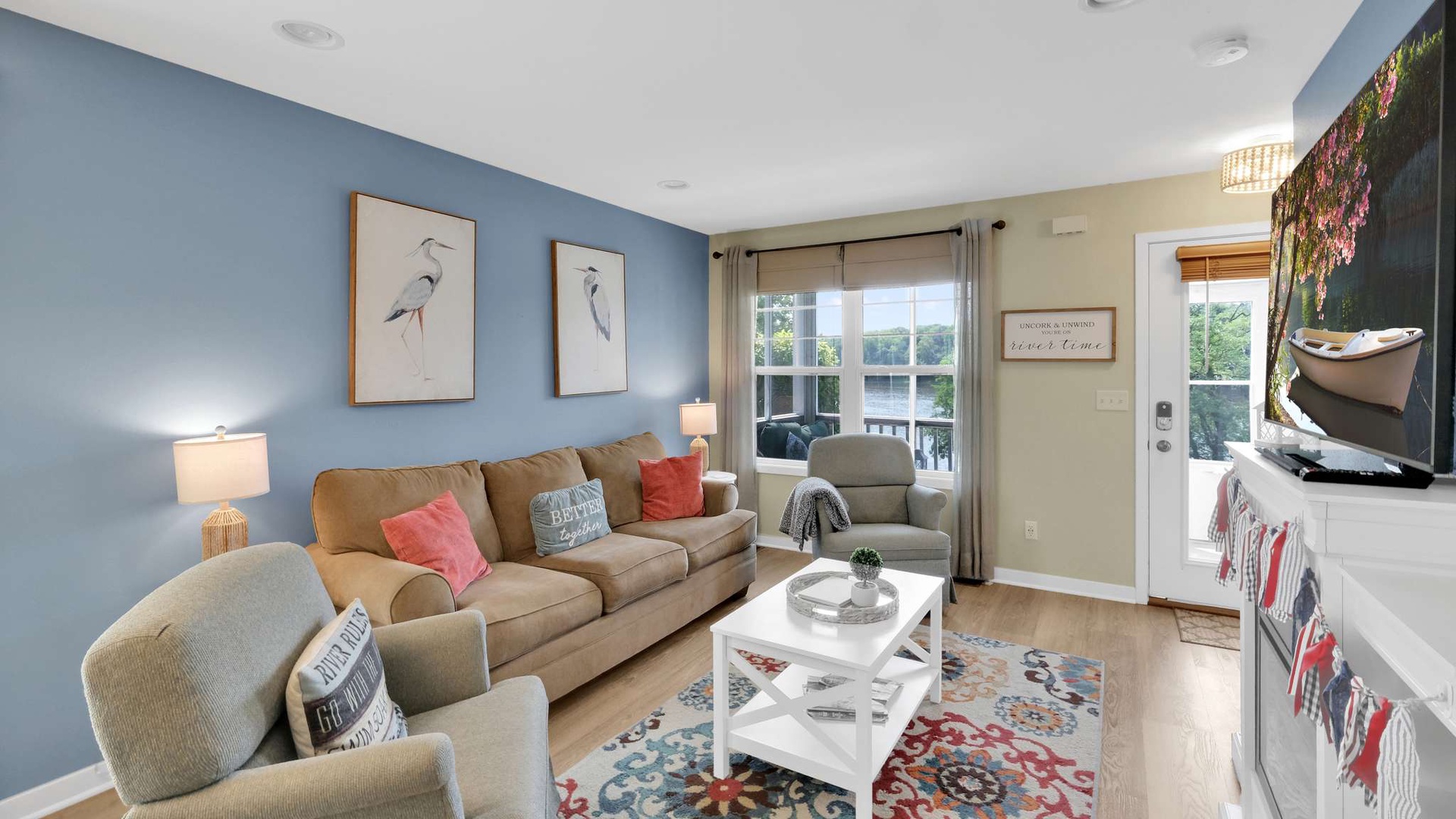 Sink into plush seating while natural light fills your bright living space, complete with entertainment and charming coastal artwork.