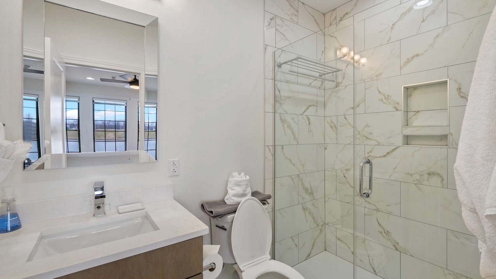 Indulge in your private marble sanctuary with a spacious glass shower and sleek vanity—pure luxury awaits.