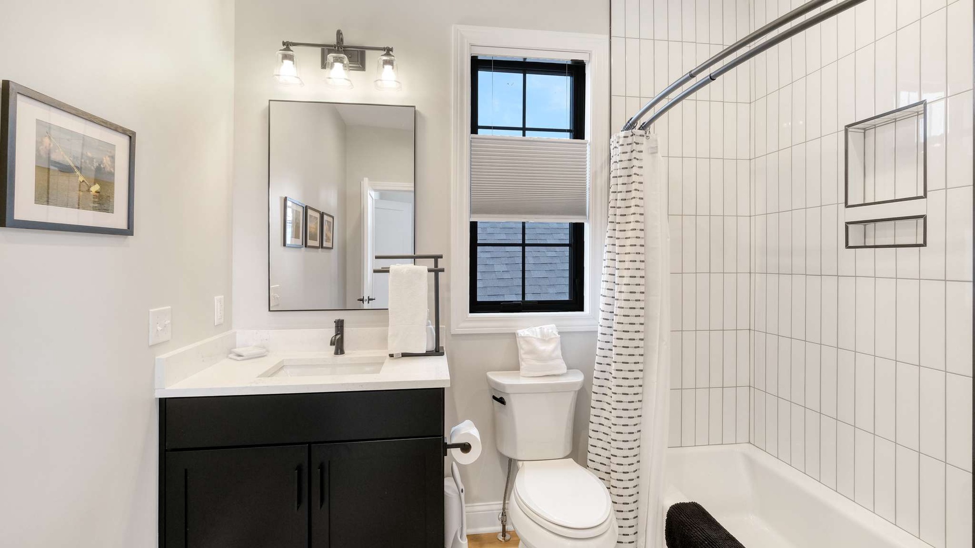 Step into your pristine bathroom with modern vanity, spacious shower, and fresh white towels awaiting your arrival.