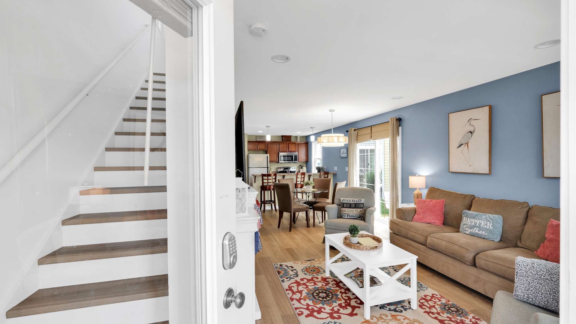 Your open-concept living space blends comfort with coastal charm, featuring cozy seating and seamless flow to your fully equipped kitchen.