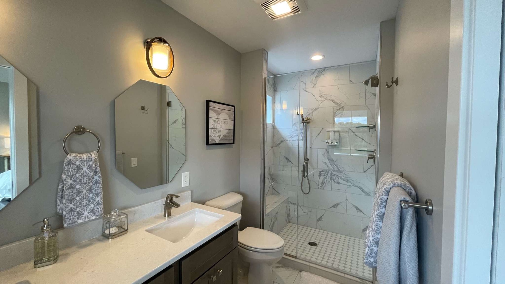 Indulge in your private spa-like retreat with elegant marble shower, modern fixtures, and warm lighting that makes every morning feel luxurious.
