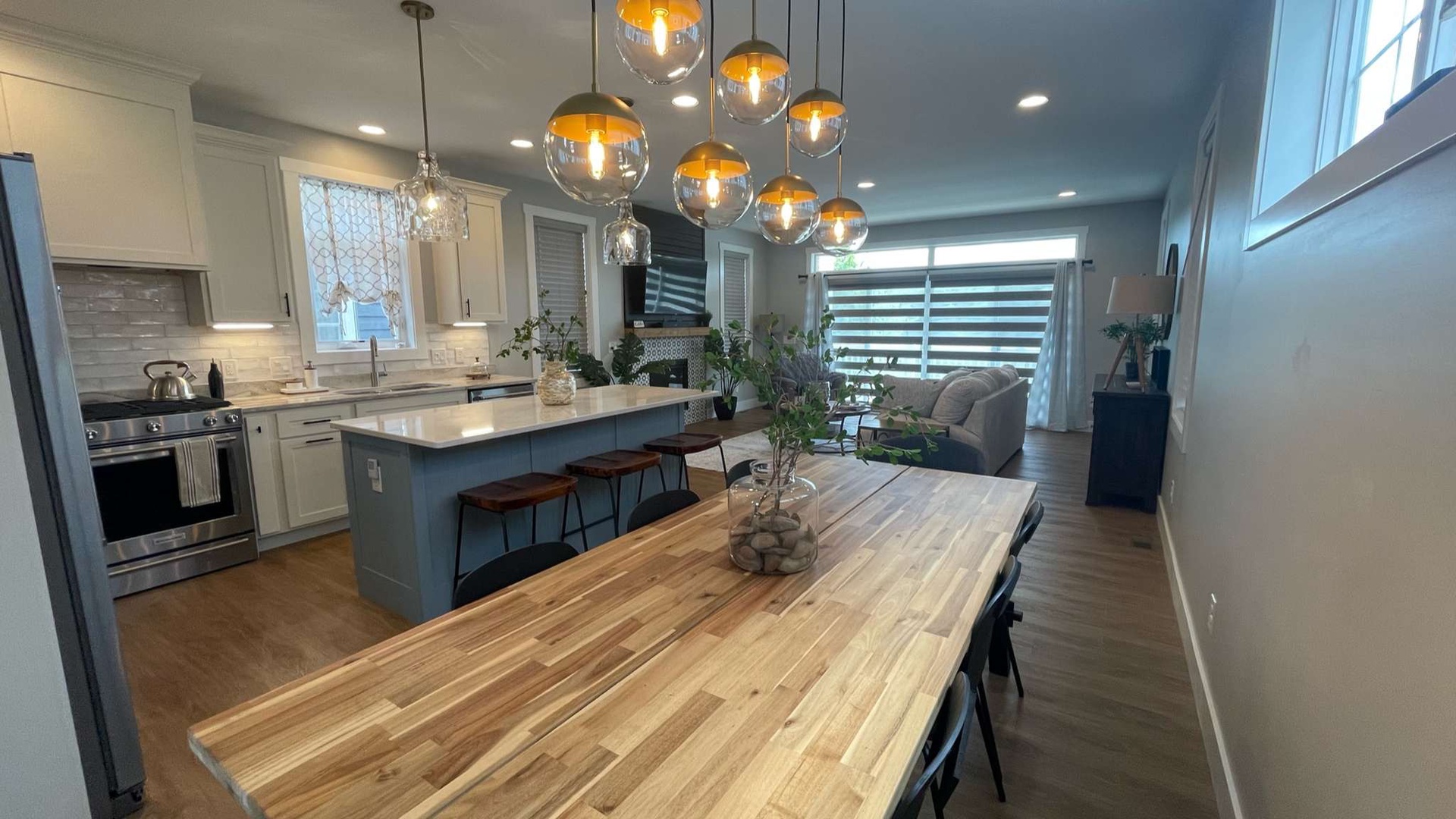 Gather around this stunning open-concept space where golden pendant lights illuminate your culinary adventures and memorable meals together.