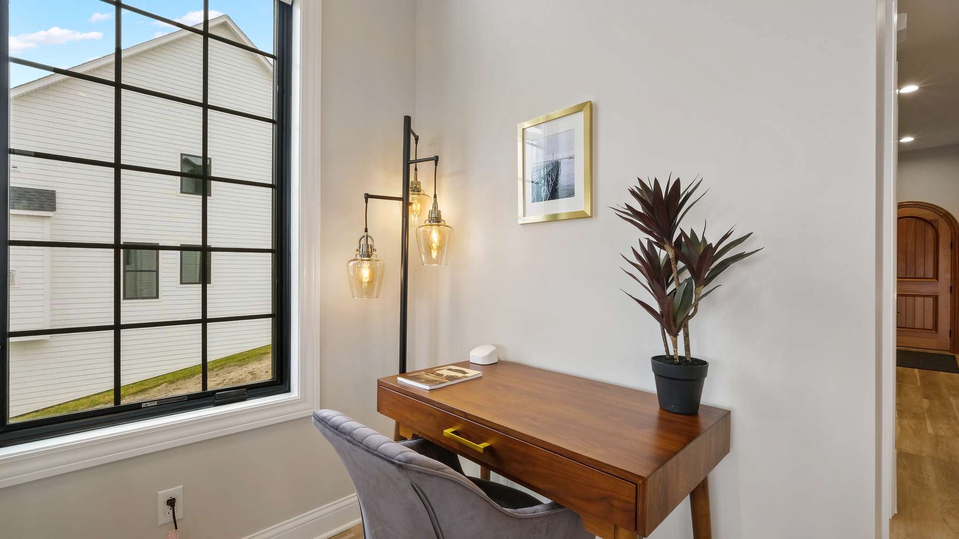 Your stylish workspace awaits with warm pendant lighting and modern furnishings, perfect for productive mornings by the window.