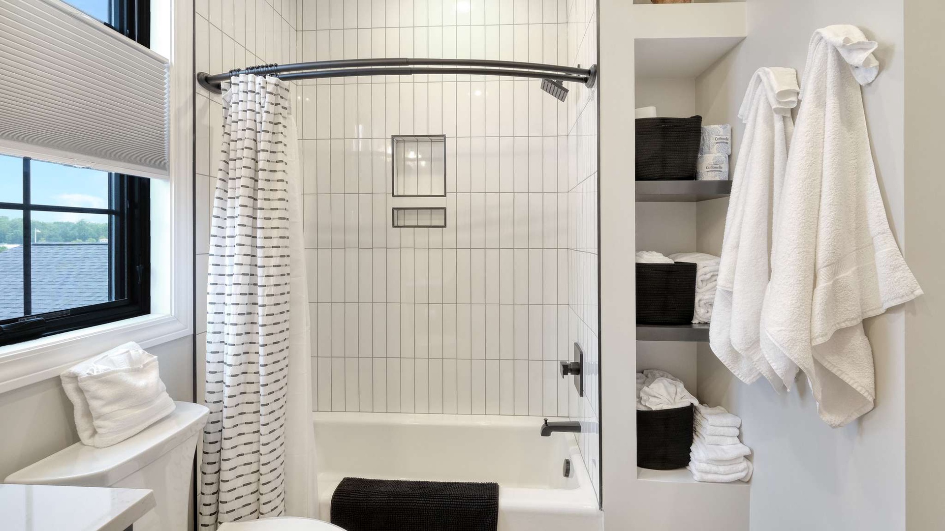 Step into your modern bathroom sanctuary with pristine white subway tile, curved shower curtain, and fluffy towels waiting for your relaxation.