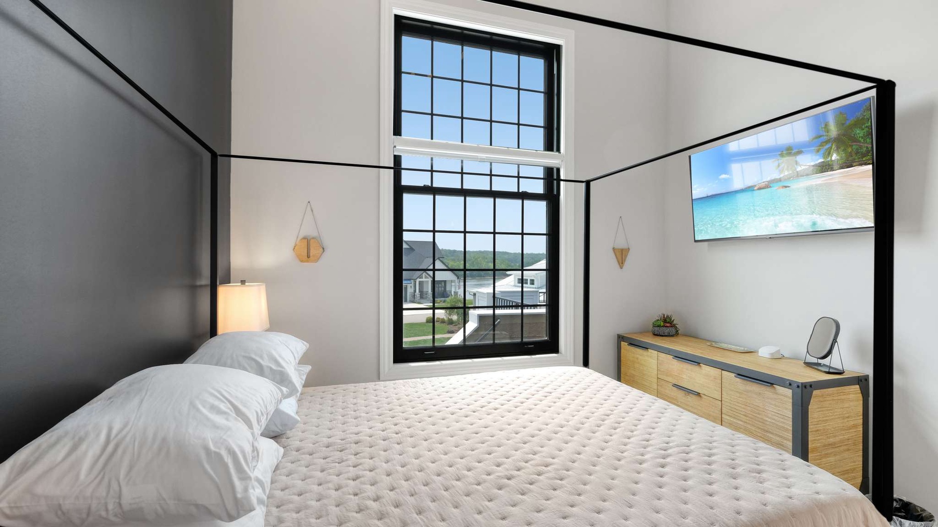 Sleep peacefully in your stylish bedroom with modern canopy bed and large windows bringing in natural light.