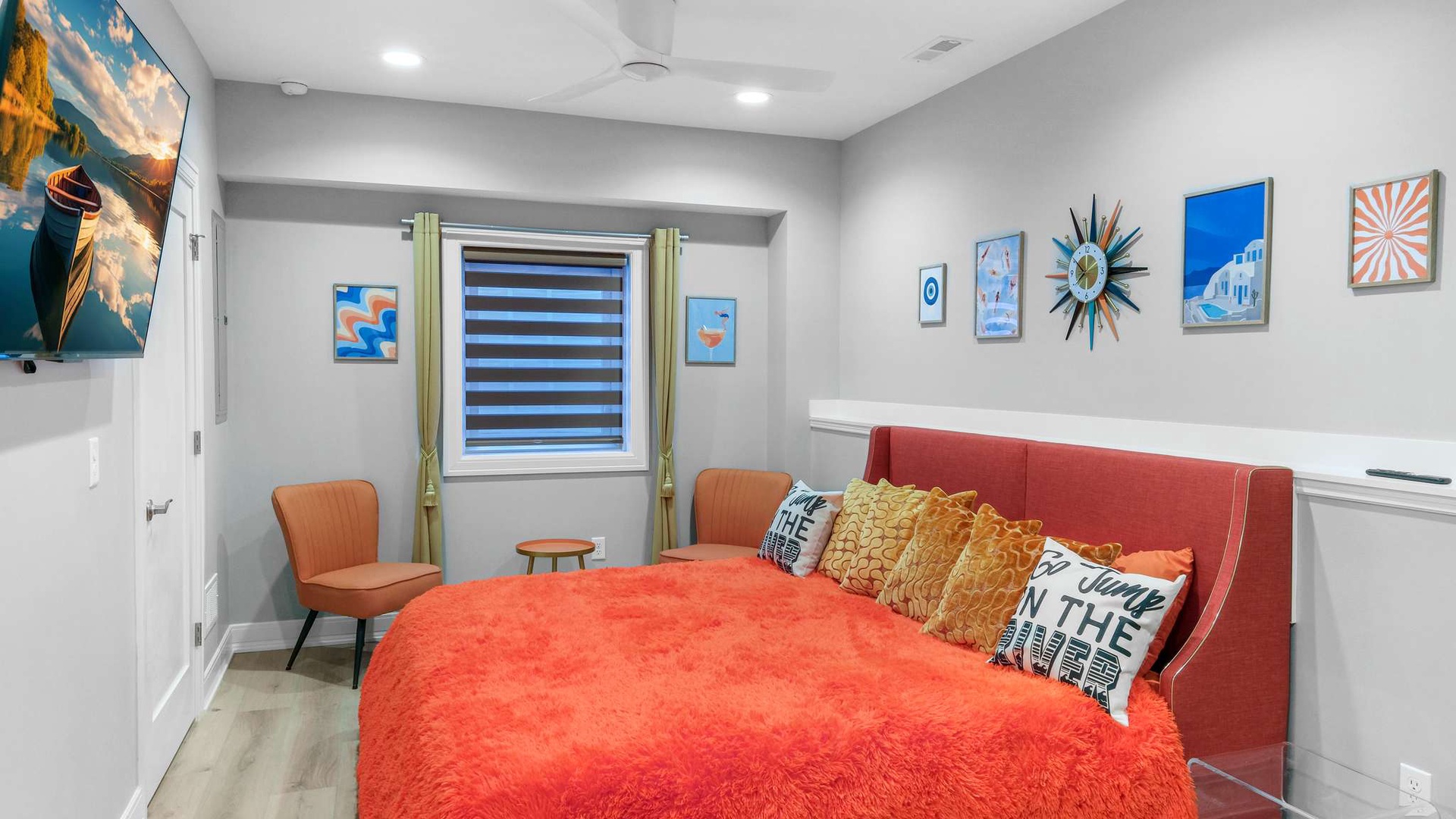 Sink into this vibrant bedroom where coral tones and cheerful artwork create your perfect retreat for restful nights.