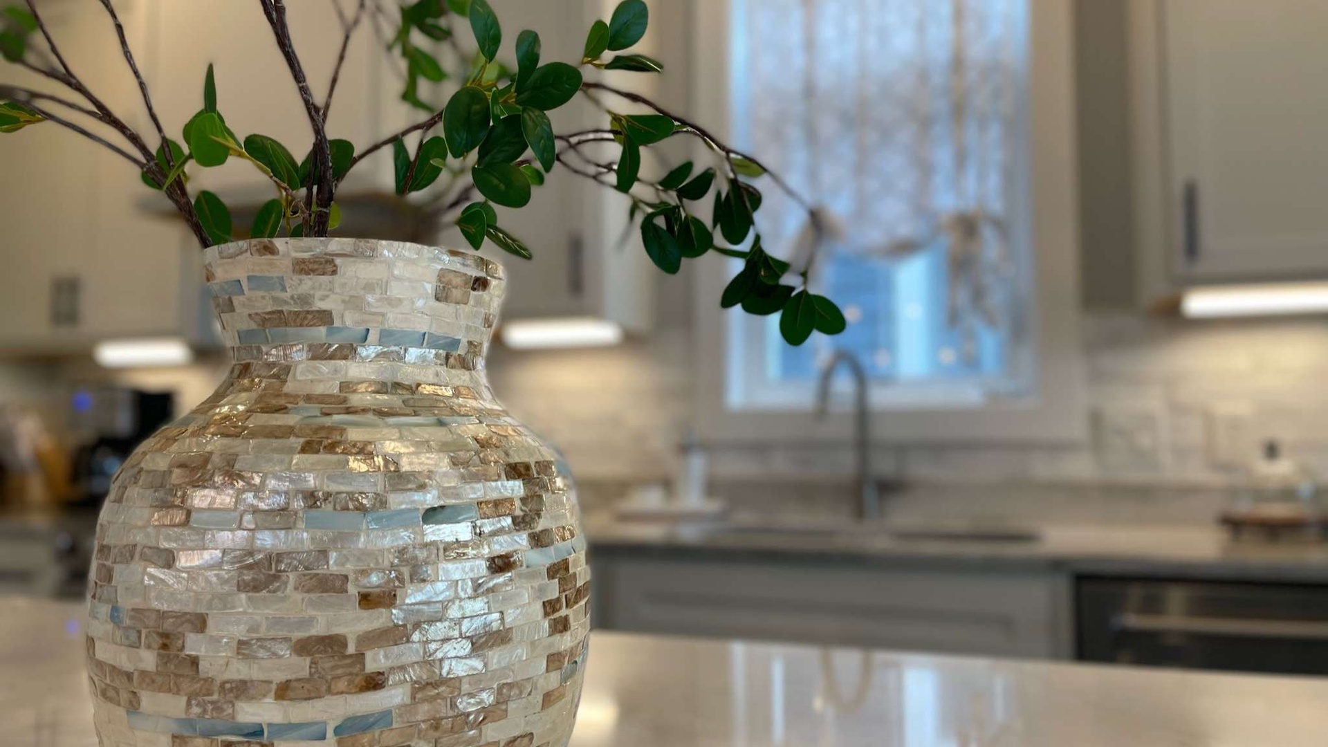 Your kitchen's elegant mosaic vase adds warmth to your culinary space, where natural light flows through while you cook.