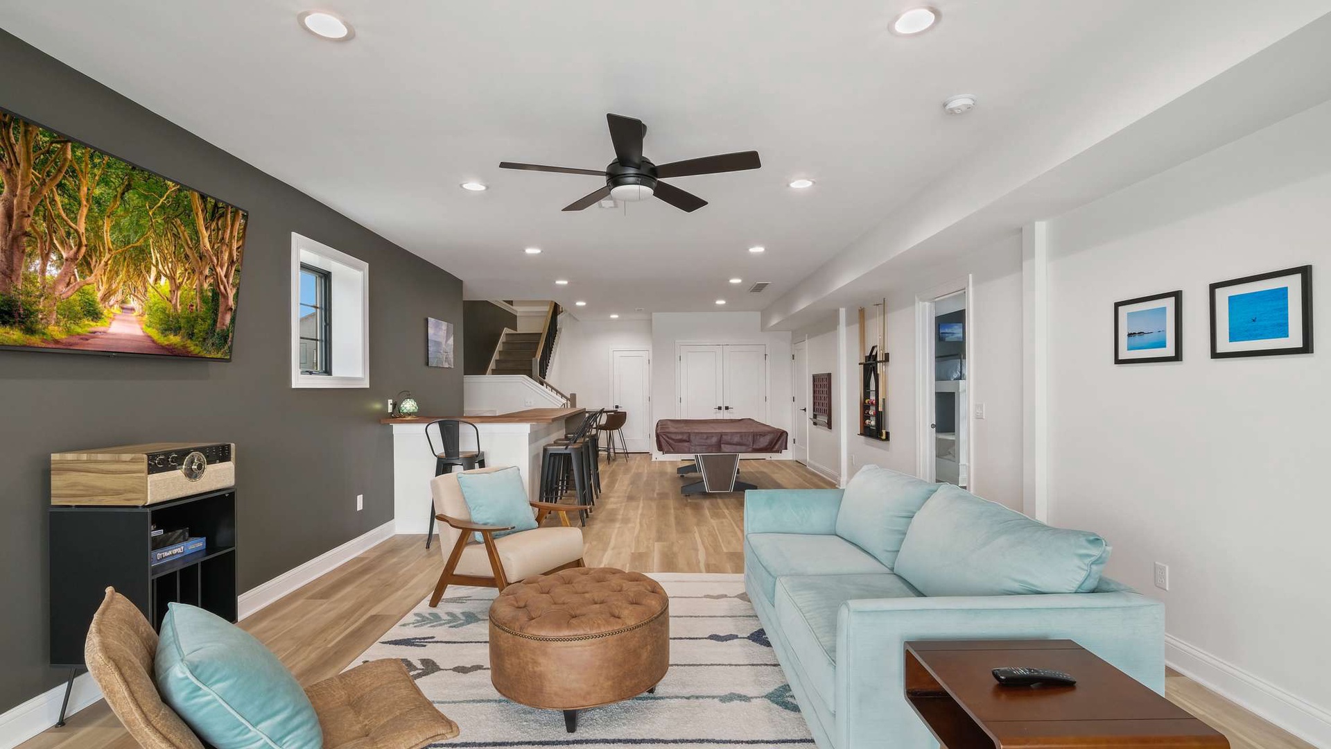 Sink into plush coastal-blue seating while the ceiling fan keeps you cool in this airy open-concept space.