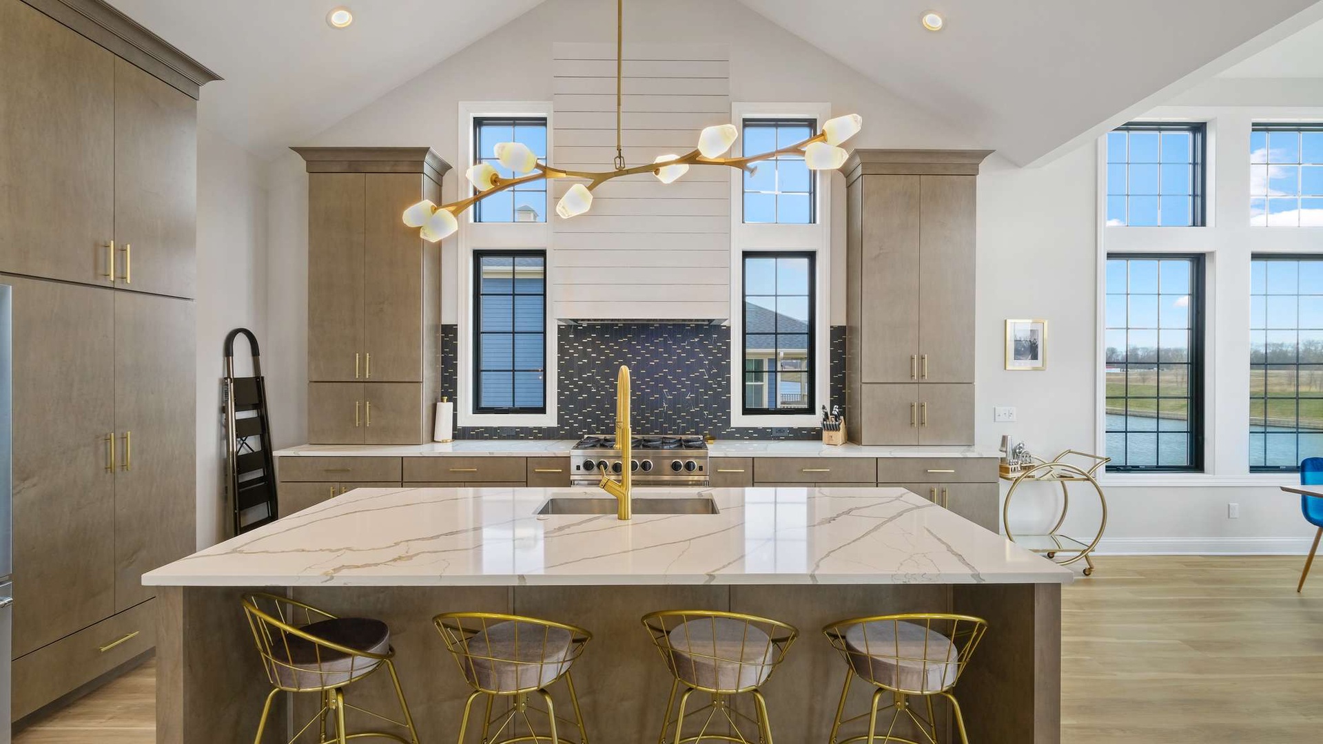 Cook and gather in your stunning gourmet kitchen featuring sleek marble counters, modern fixtures, and natural light streaming through tall windows.