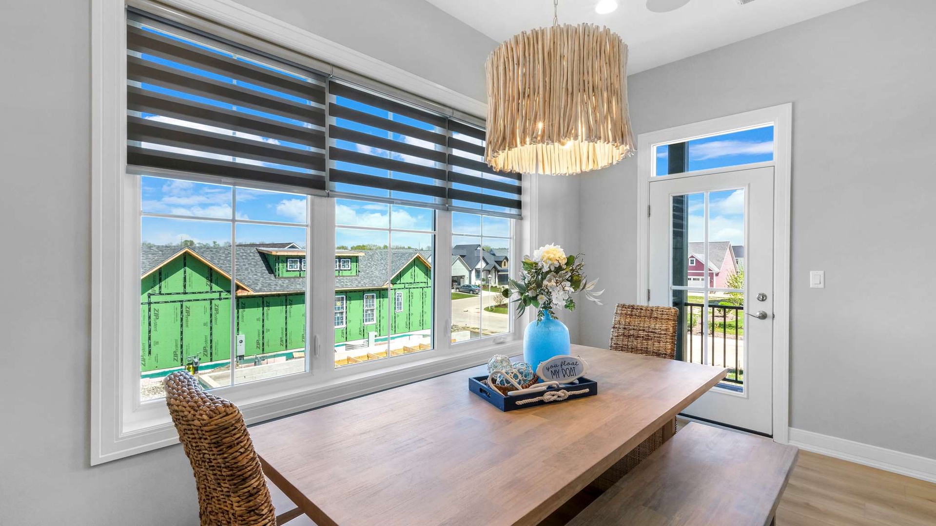 Gather around your private dining table with natural light streaming through stylish blinds and a charming neighborhood view.