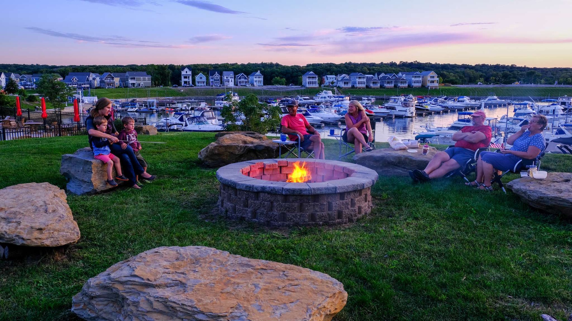 Gather around the crackling fire pit as sunset paints the sky, sharing stories while boats rest peacefully in the marina below.