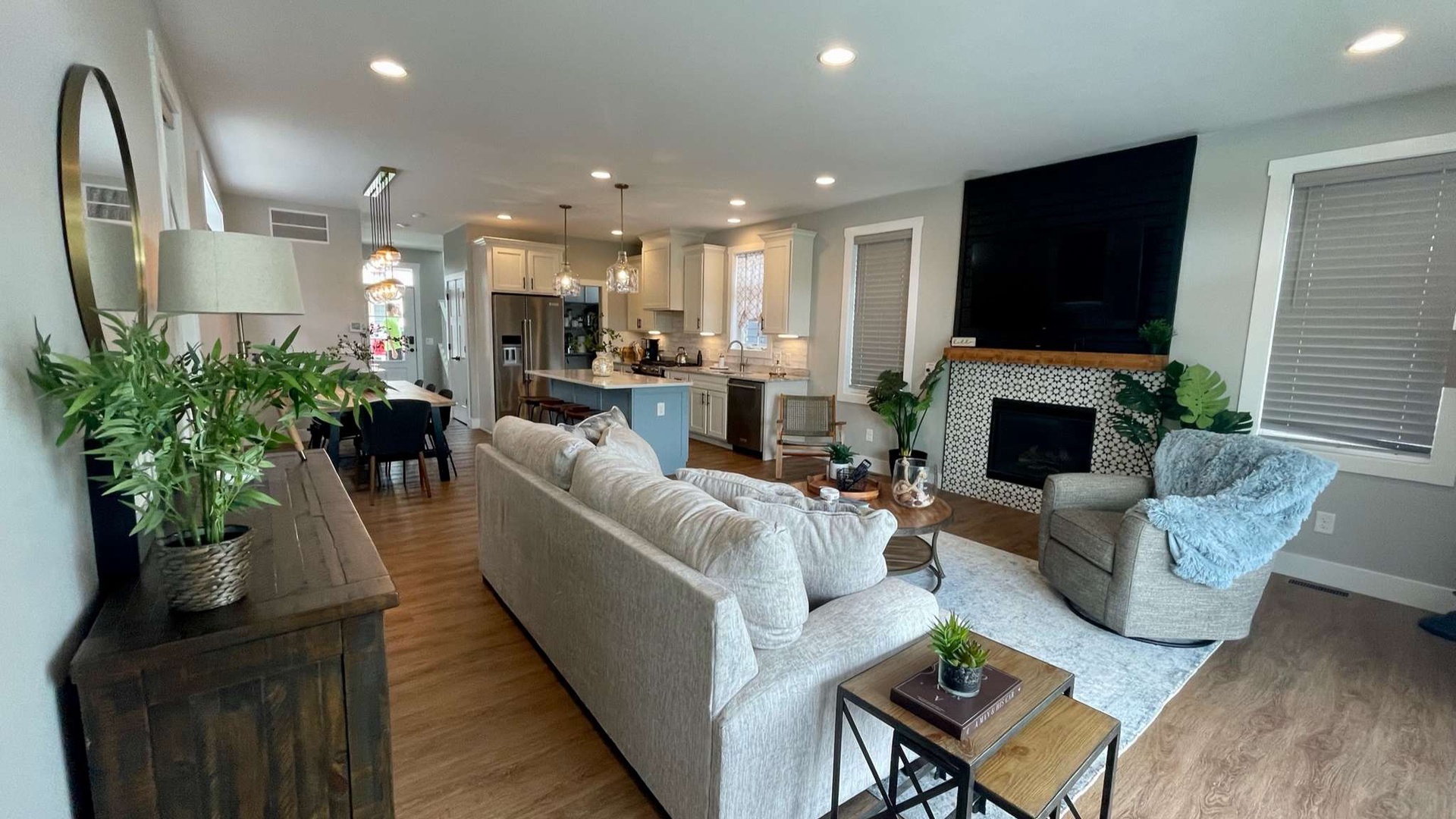 Sink into plush sofas in your open-concept living space, where modern comfort meets stylish design with a cozy fireplace and fully equipped kitchen.