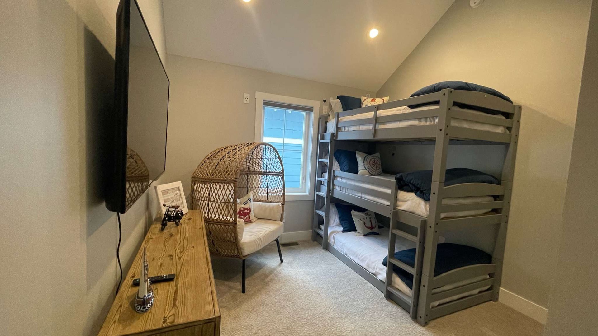 Your kids will love this cozy bunk room with triple beds and fun peacock chair for reading adventures together.
