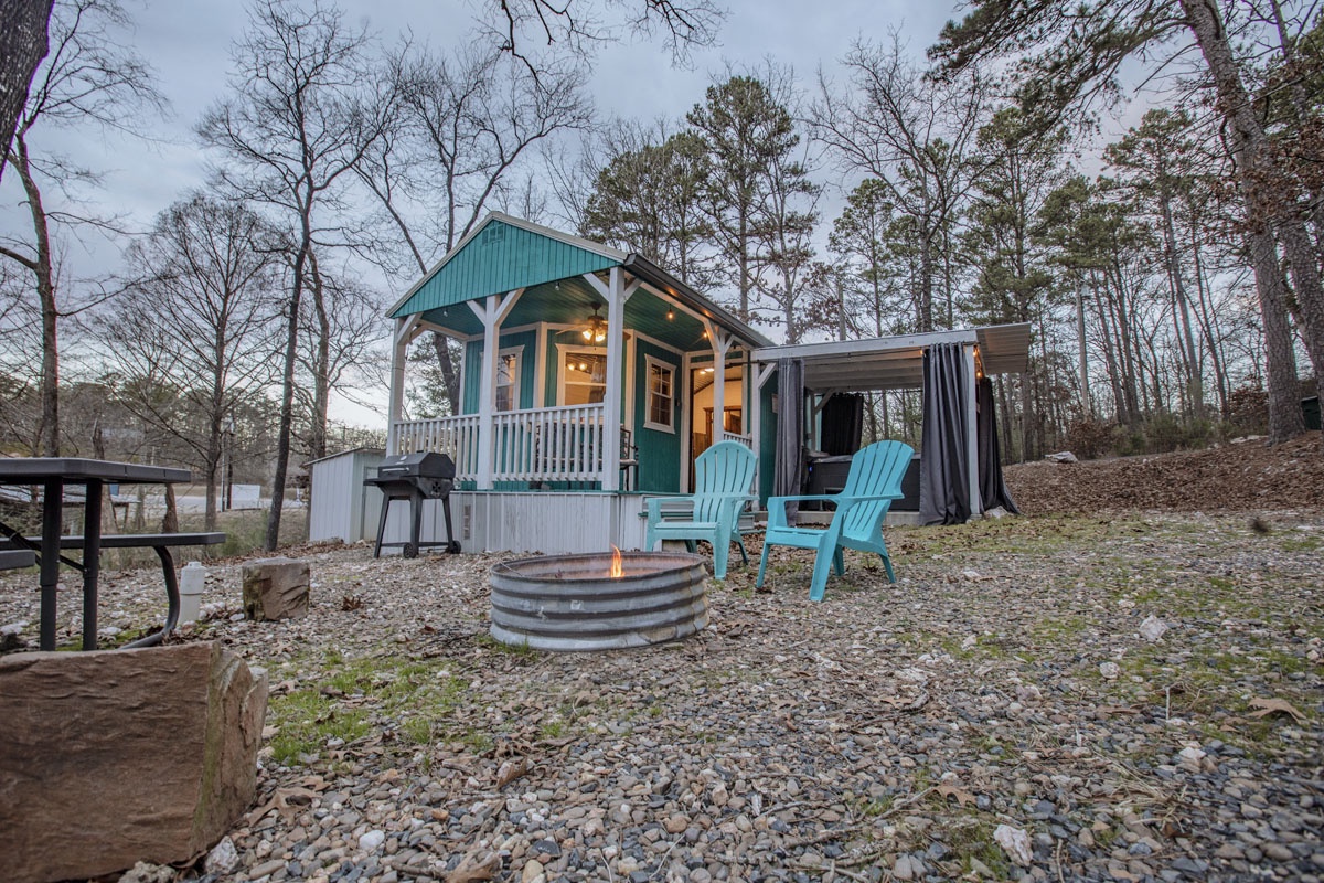Charming cottage surrounded by peaceful woods with outdoor seating and fire pit for cozy evenings.
