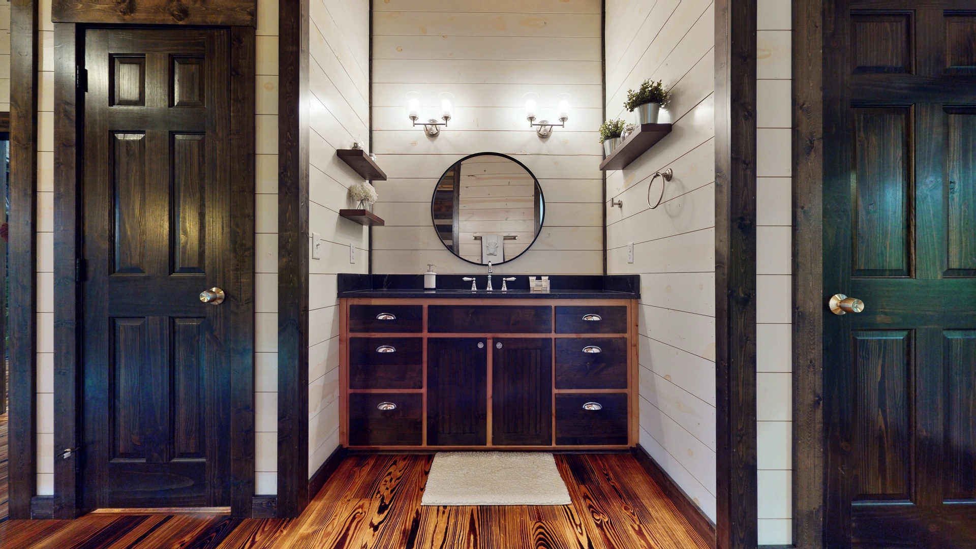 Step into your beautifully crafted bathroom with warm wood floors, classic shiplap walls, and thoughtful storage that blends rustic charm with modern comfort.