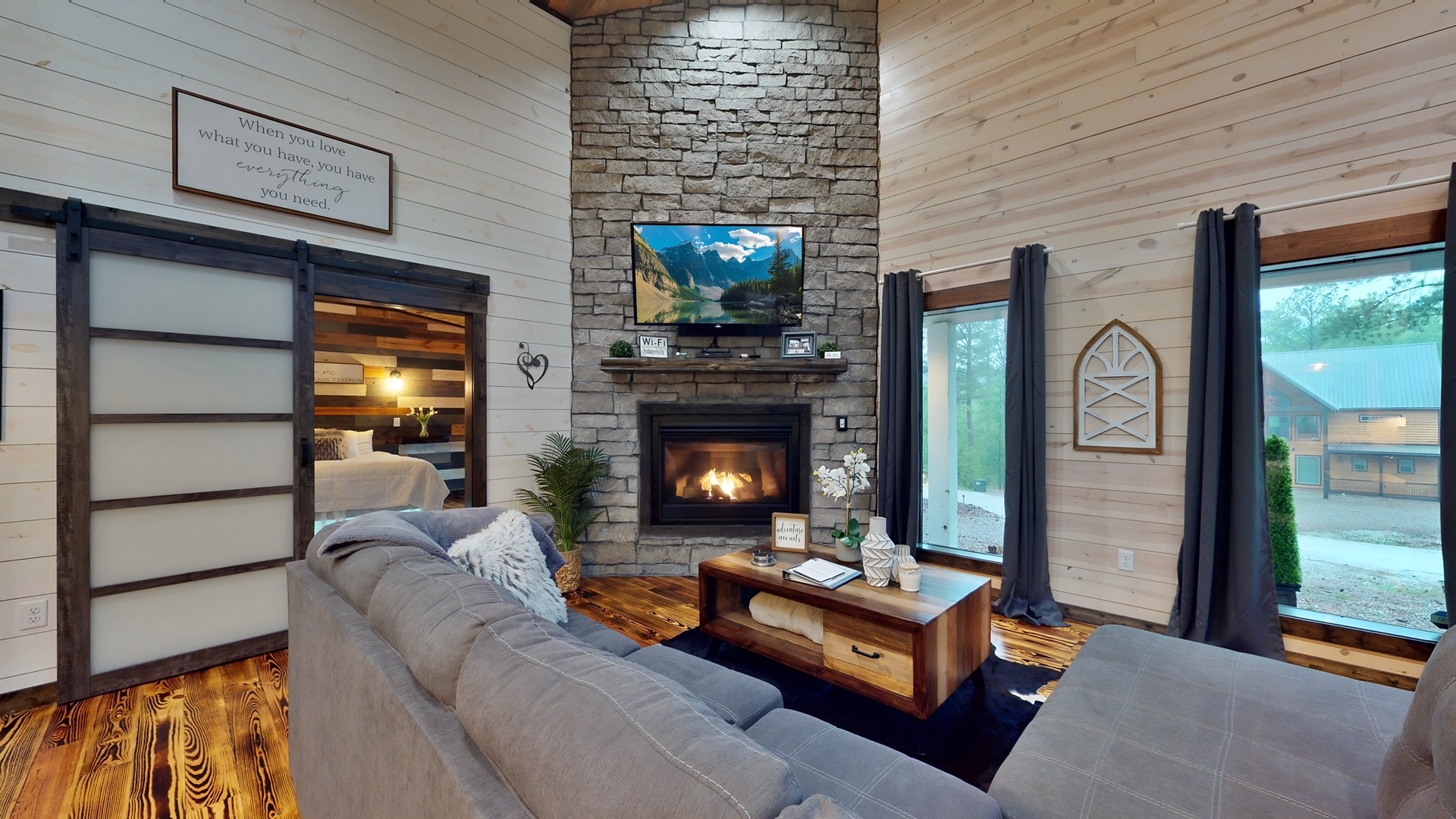 Relax in your cozy living room with a crackling fireplace, rustic stone accents, and soft seating perfect for unwinding after a day of adventure.