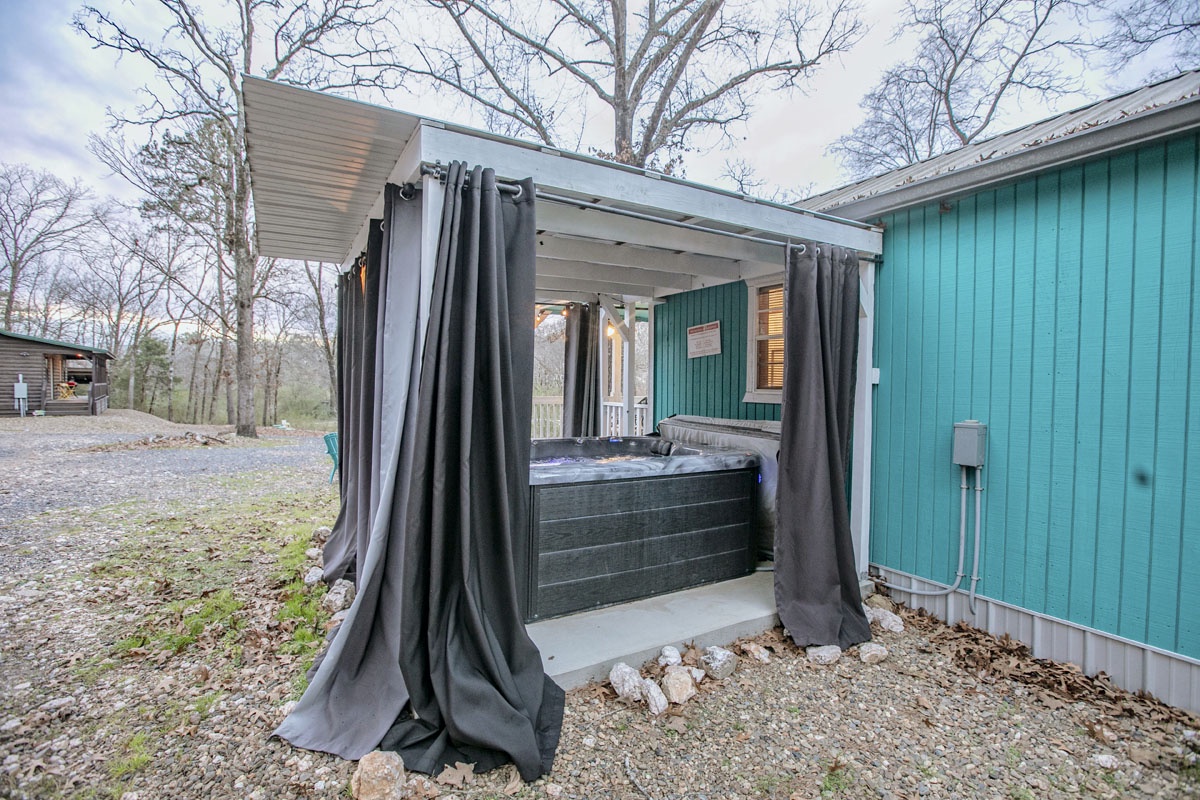 Soak under the stars in your private hot tub, surrounded by peaceful woods and elegant curtains for complete privacy.