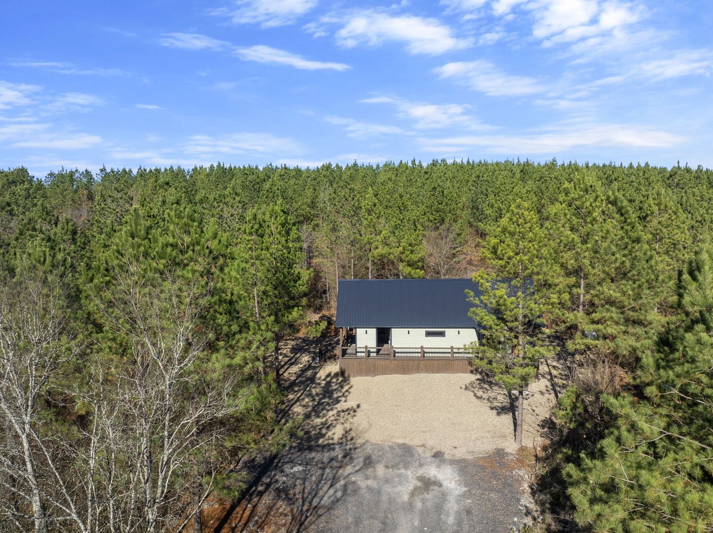 Modern retreat nestled in pristine forest surroundings with expansive outdoor deck and private woodland setting.