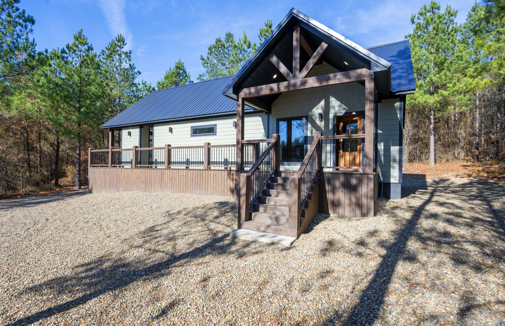 Modern cabin nestled among towering pines with spacious deck and natural forest setting for peaceful getaway.