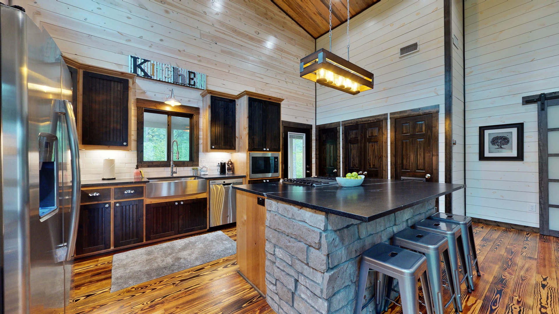 Gather around the spacious stone island in this beautifully crafted kitchen, where rustic wood beams meet modern appliances. You'll love the warm, inviting atmosphere and open layout—perfect for cooking and sharing meals together.