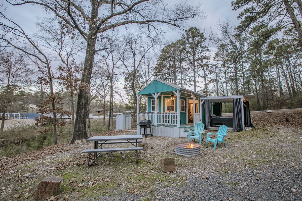 Your charming tiny home retreat awaits with cozy fire pit evenings and peaceful woodland surroundings.