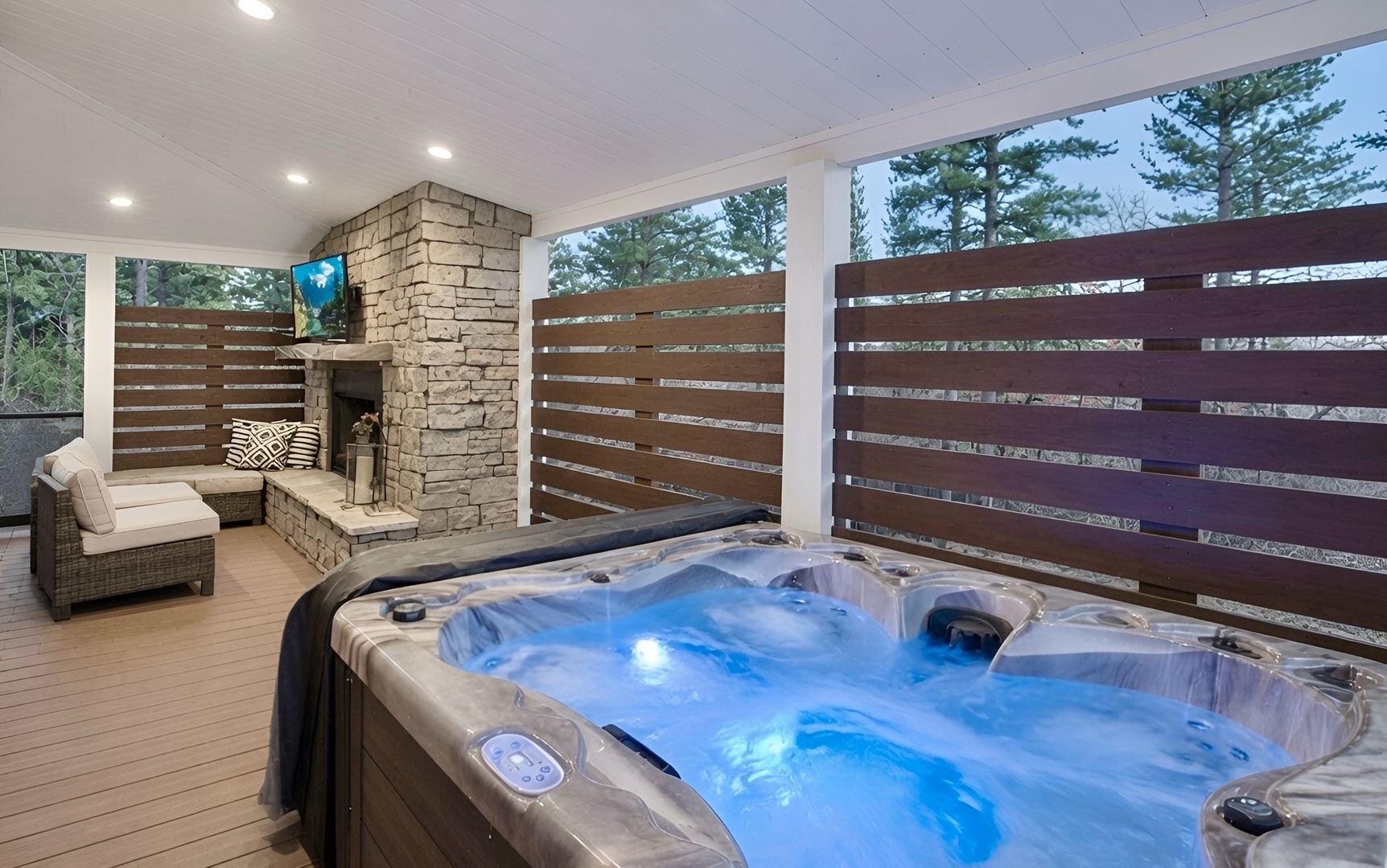Unwind in your private hot tub on the covered deck, where a cozy outdoor fireplace invites quiet evenings under the trees.