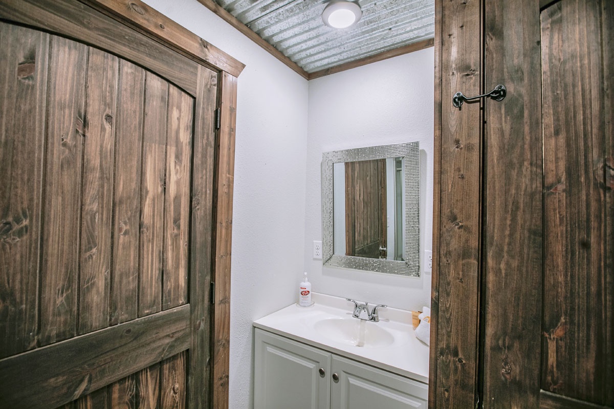 Step into your rustic bathroom featuring weathered wood accents and modern amenities for comfort.