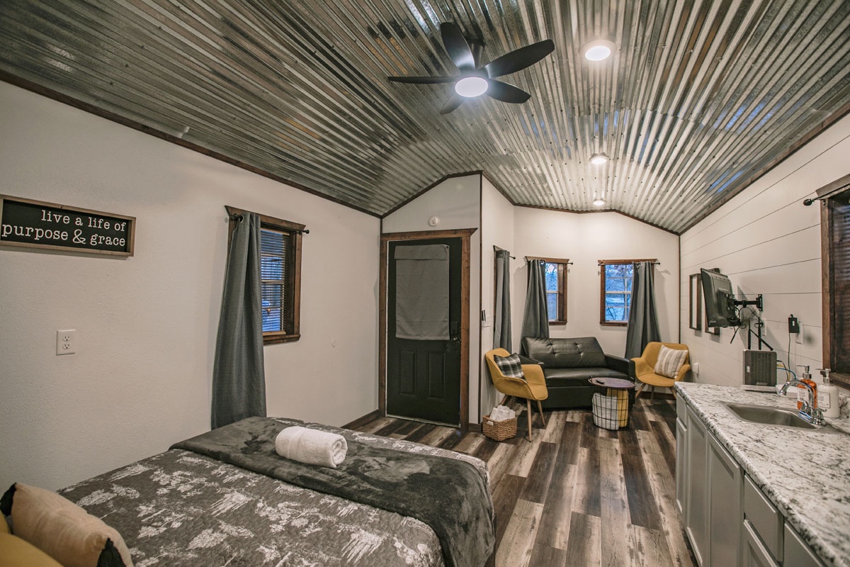 Unwind in your stylish studio with rustic tin ceilings, cozy living space, and modern kitchen—perfect for a peaceful retreat.