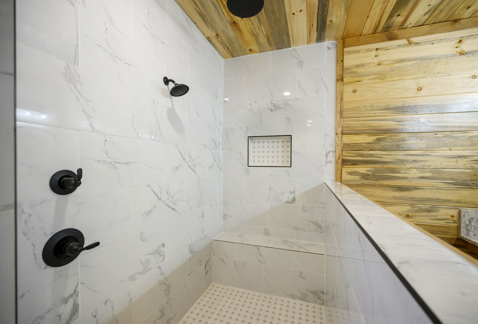 Step into your private spa-like shower with elegant marble tiles, dual shower heads, and built-in bench for ultimate relaxation.