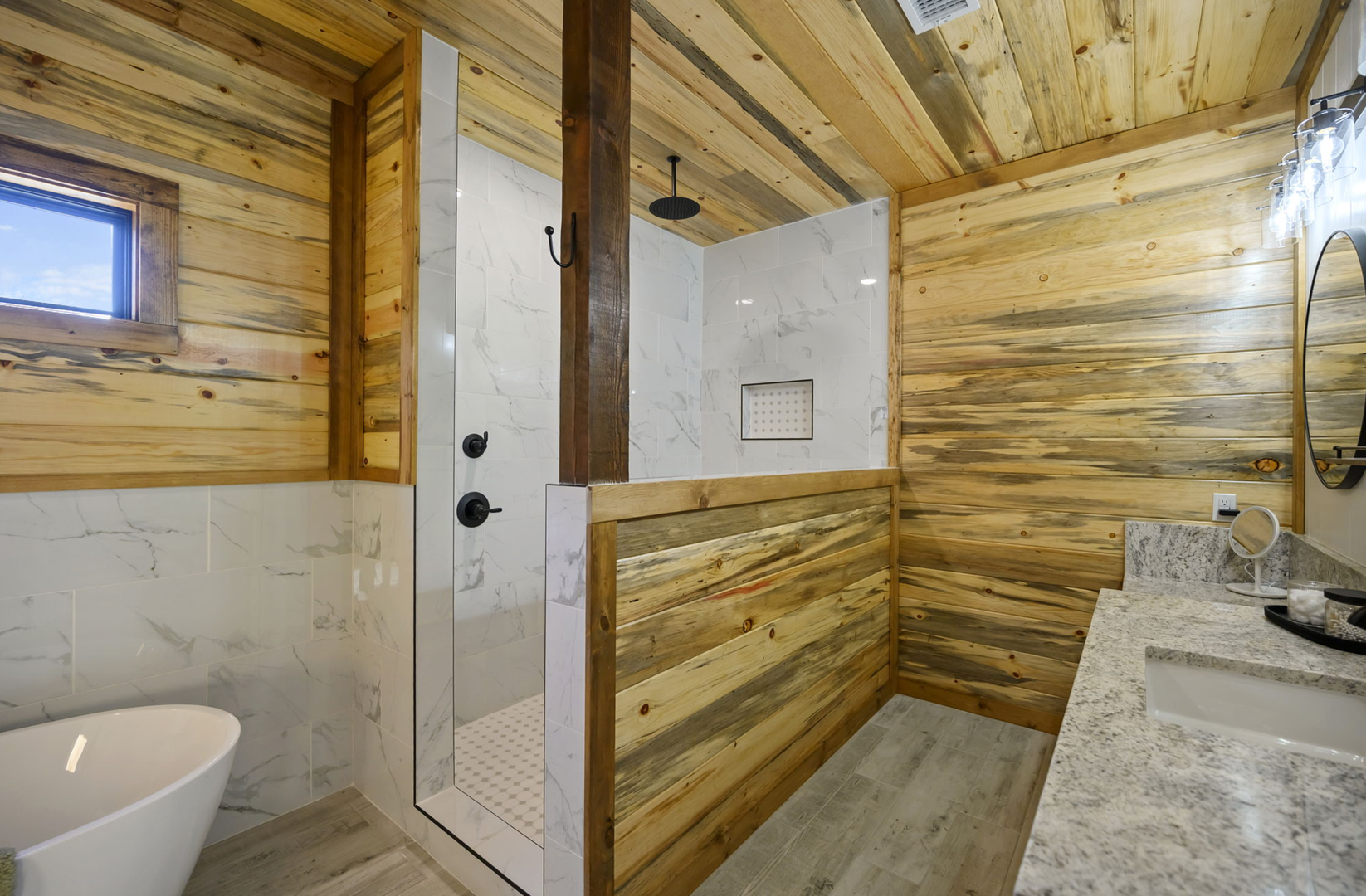 Relax in your stunning bathroom featuring warm wood and marble, with a rainfall shower and soaking tub perfect for unwinding.