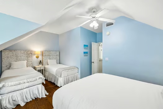 Rest easy in your serene bedroom with three comfortable beds, vaulted ceilings, and soothing blue accents that invite a peaceful night's sleep.