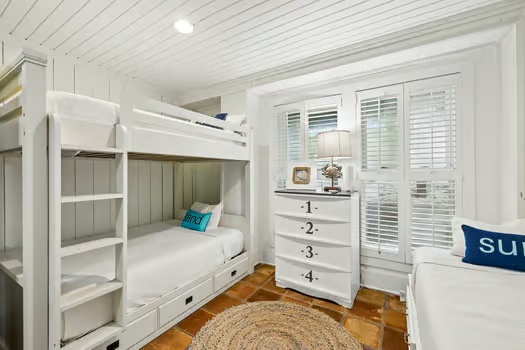 Your kids will love this charming bunk room with built-in storage and plantation shutters that invite soft natural light while keeping the space cozy and private.