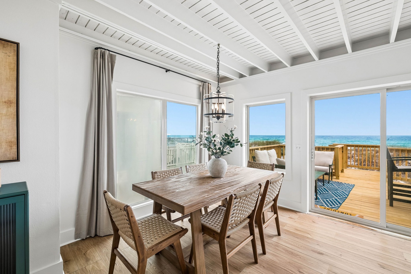 Picture yourself dining here—natural light pouring in through floor-to-ceiling windows framing sparkling turquoise waters. This bright, coastal-chic space opens to your private deck, blending indoor comfort with breathtaking ocean views.