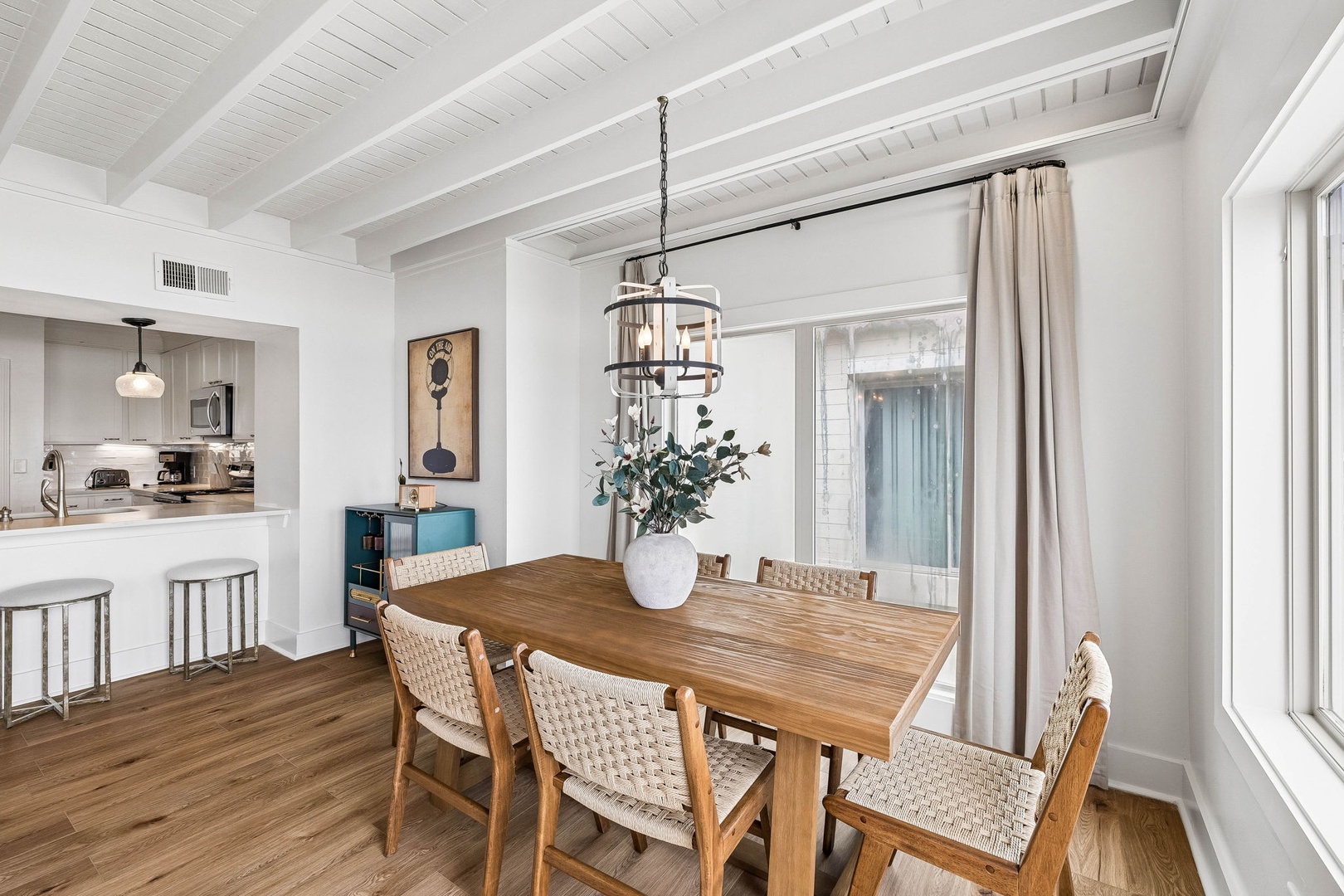 Gather around this warm wood table for memorable meals. The open-concept layout flows seamlessly into your well-appointed kitchen, creating a bright, airy space perfect for sharing stories.