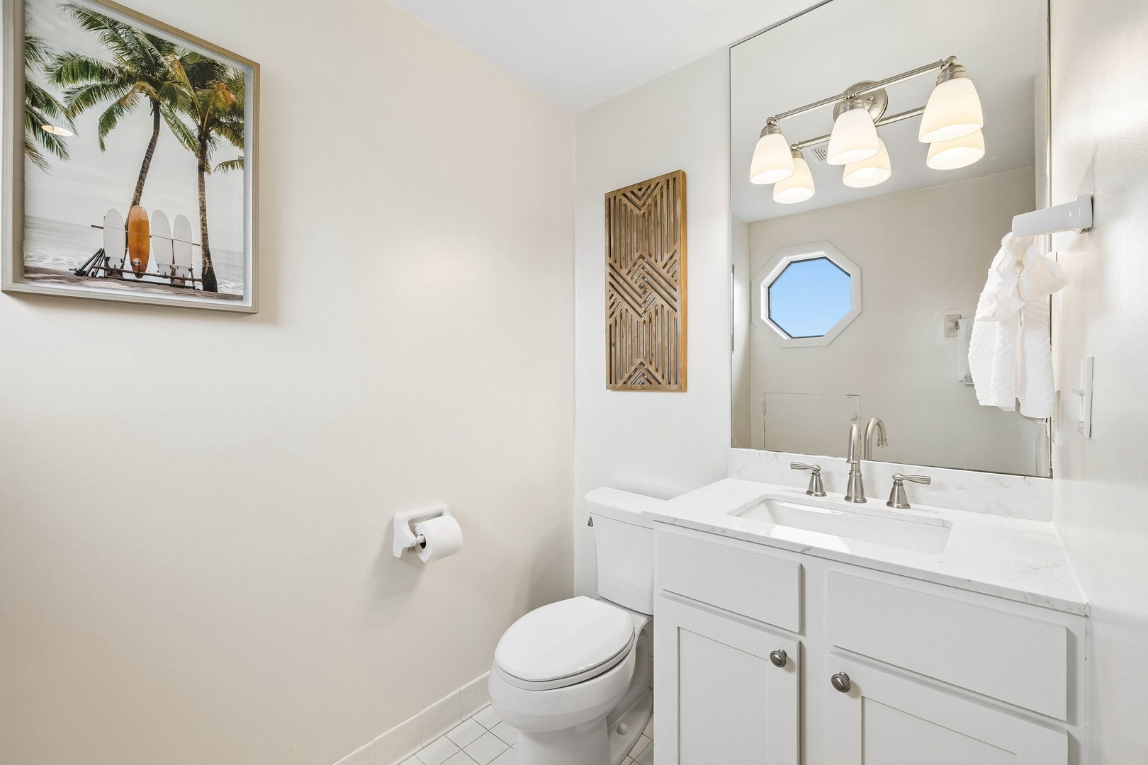 Your bright, beachy bathroom blends coastal calm with modern comfort—fresh towels, a clean vanity, and tropical artwork invite you to unwind after a day of adventure.