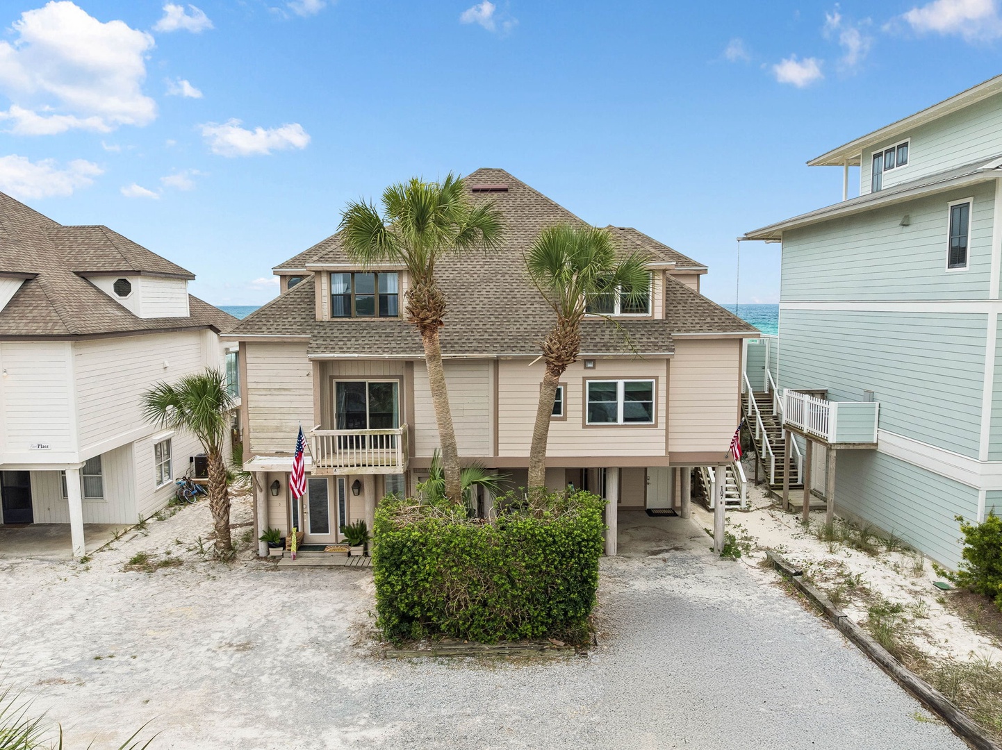 Beachside coastal home with palm trees and ocean views, nestled in a quiet residential neighborhood just steps from the shore.