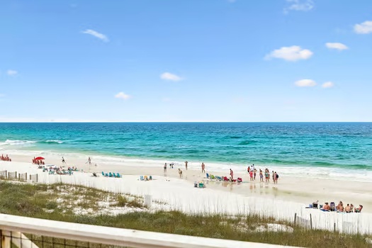 Pristine white sand stretches along turquoise waters, perfect for your sunny beach days. Dune grasses sway in the breeze while gentle waves invite you to swim and play.