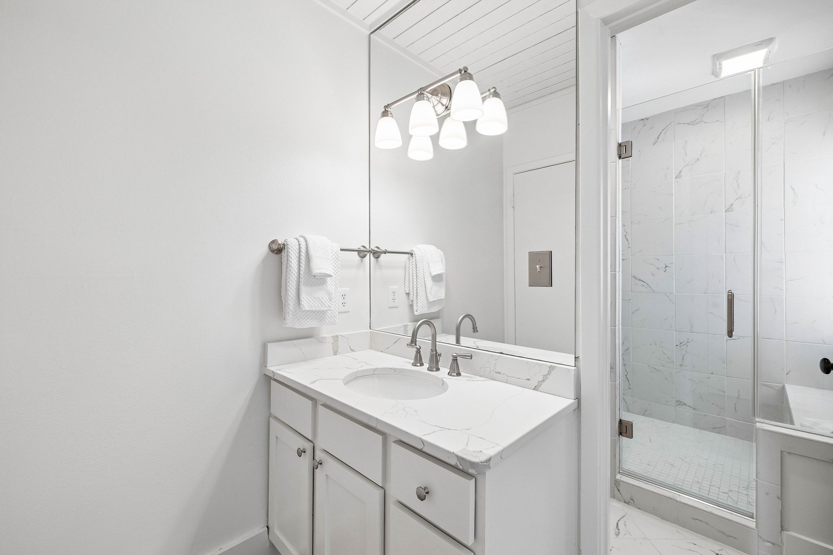 Step into your bright, beautifully appointed bathroom, where marble-style details and fresh white linens create a spa-like sanctuary for your morning routines and evening unwinds.