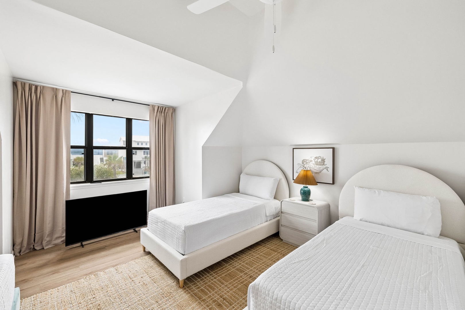 Settle into your bright, restful twin bedroom where soft linens, vaulted ceilings, and calming natural light create a serene retreat after a day of exploration.