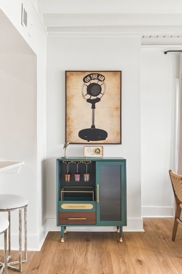 A charming vintage-inspired corner features an elegant sideboard paired with retro artwork and a classic radio, adding character and nostalgic warmth to your stay.