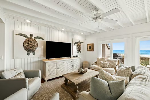 Relax in your bright coastal living space, where sea turtle art and ocean breezes create the perfect beach getaway. Kick back on plush seating and catch the view through open doors to the shore.