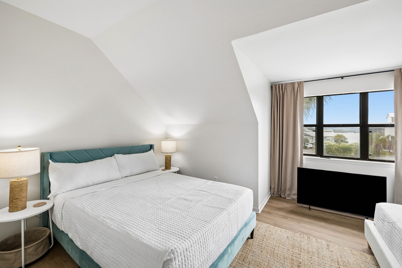 Settle into your cozy bedroom, where crisp linens invite restful sleep and sunshine filters through the window onto warm wood floors. Your peaceful retreat awaits.