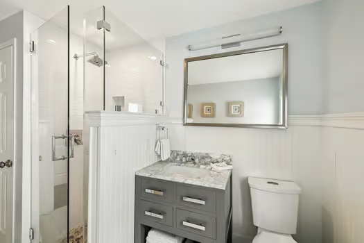 Step into a fresh, spotless bathroom with a spacious walk-in shower, modern vanity with marble countertop, and elegant frameless glass enclosure waiting for you.
