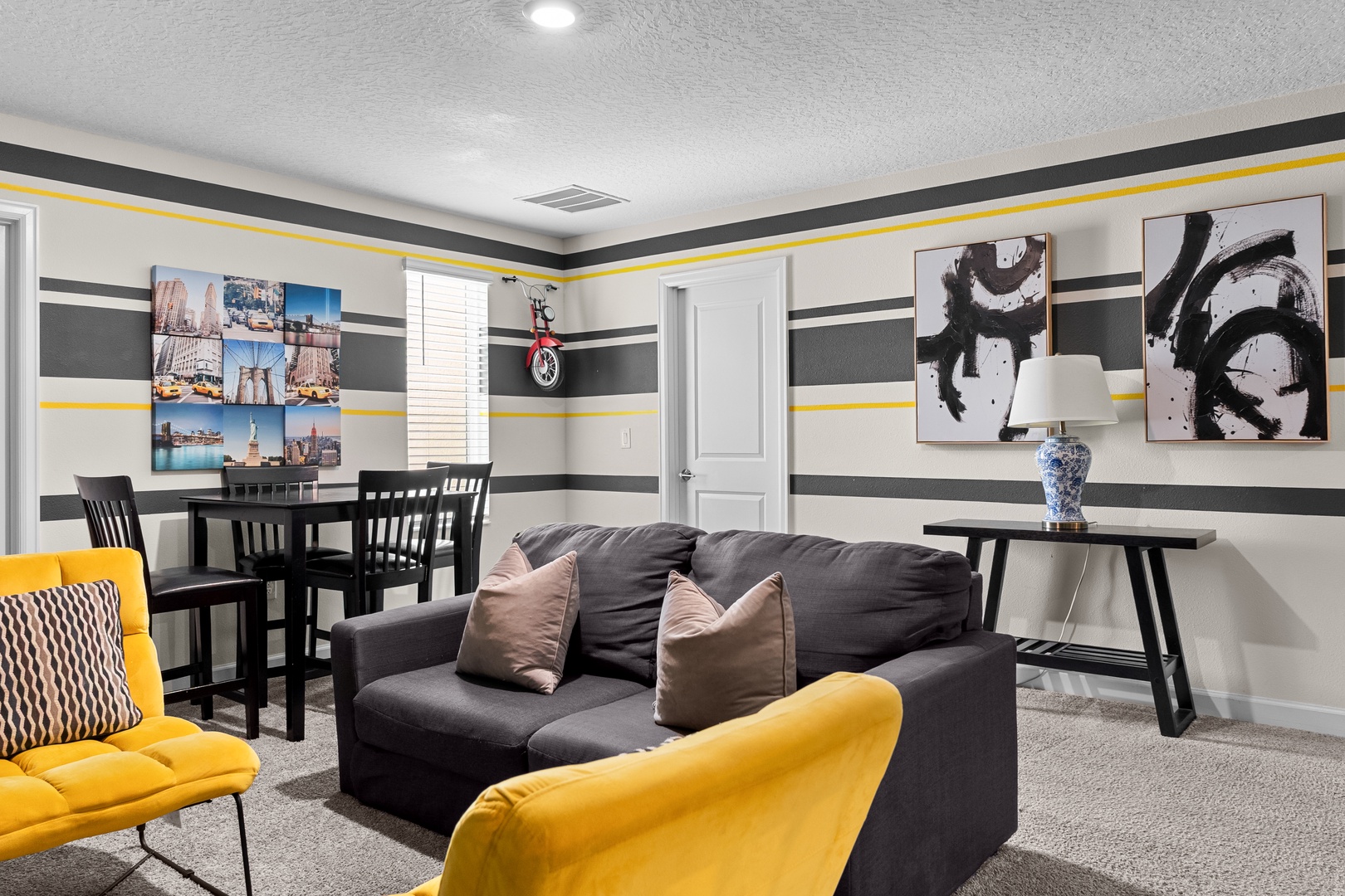 Unwind in your stylish living space featuring bold yellow accents, comfortable seating, and thoughtful artwork creating the perfect atmosphere for relaxation.