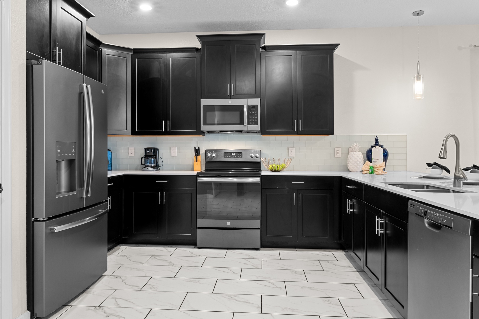 Cook your favorite meals in this sleek modern kitchen with stainless steel appliances and elegant dark cabinetry.