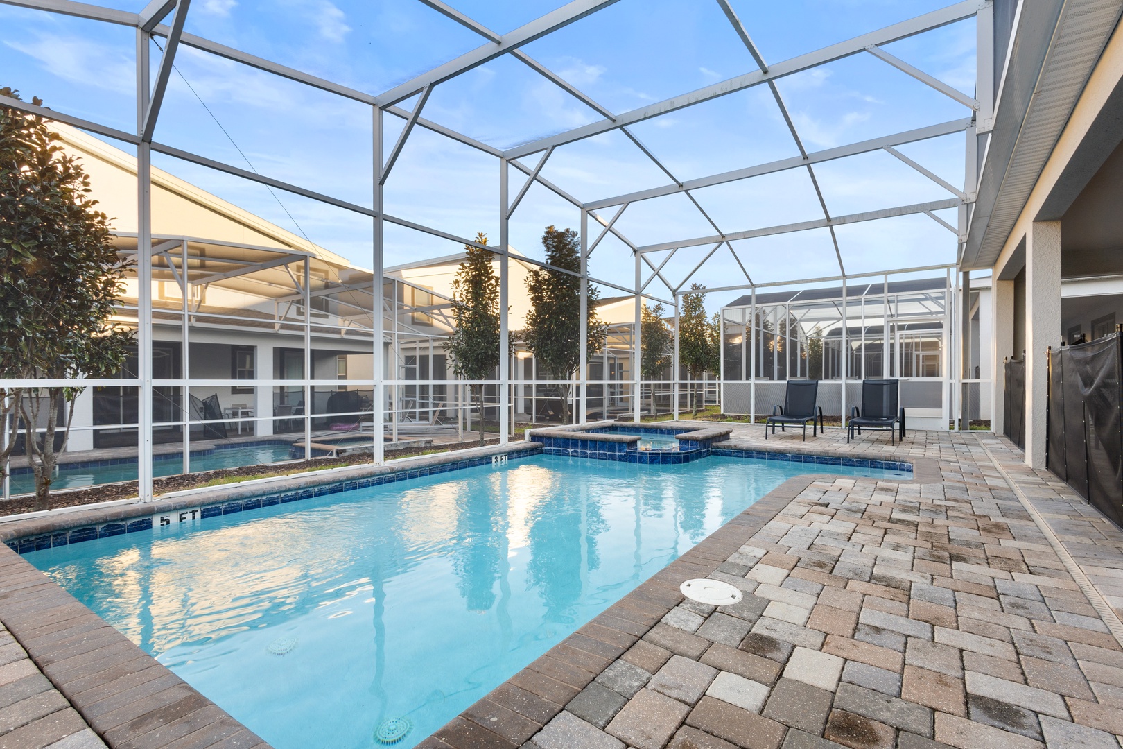 Your private oasis awaits with crystal-clear waters and peaceful lounging under a soaring screened enclosure.